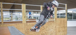 Youth jumping a scooter at the Bend Pavilion Skatepark